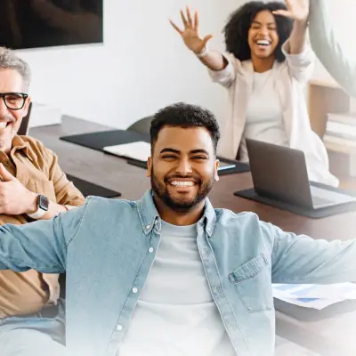 Team members high-fiving around a meeting table