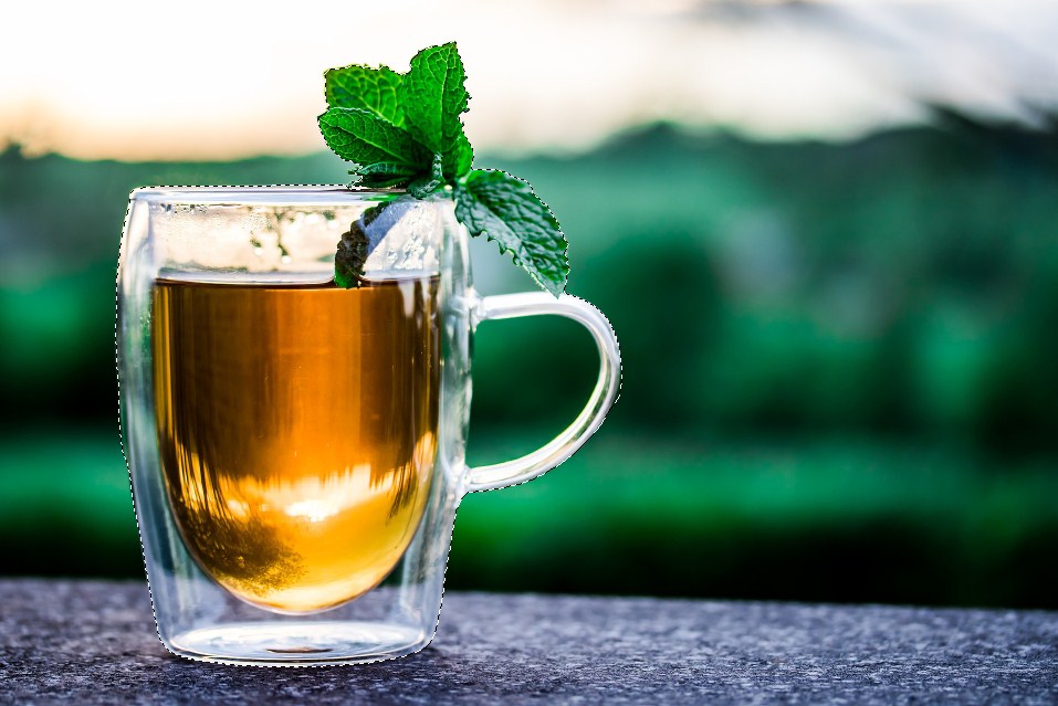 A cup of tea with basil on top